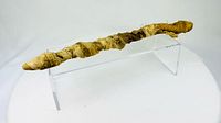 Full lateral view of linen-wrapped crocodile mummy on acrylic stand