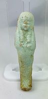 Front view showing full figure, glaze colour, facial features, crossed arms