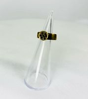 Ring front view on clear cone showing rosette bezel and patina