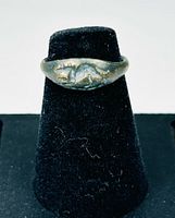 Front view showing mouse motif bezel, patina visible, ring on black display stand