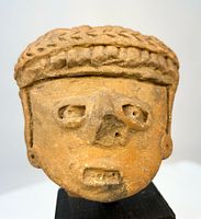 Front view of terracotta head fragment on base
