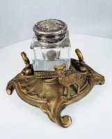 Oblique view showing entire inkwell stand, stag, pen rests, glass bottle and silver lid