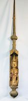 Full view of carved wooden temple finial with Buddha figure and spire