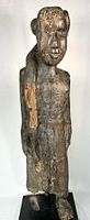 Full view of carved wooden figure on base showing overall form and condition