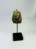 Front view of carved stone amulet on stand