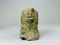 Front view of carved limestone pharaoh head fragment
