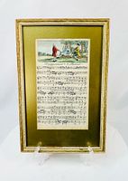 Full view of framed hand-colored engraved sheet music on easel