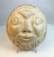 Front view of carved stone face effigy showing eyes, nose, mouth and border