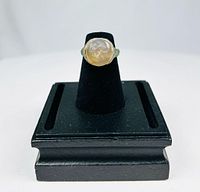 Front view of ring on black display showing carved garnet bezel portrait
