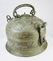 Side view showing domed lid, handle, locking clasp and engraved body