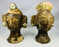 Front view of both terracotta heads showing facial features and headdresses