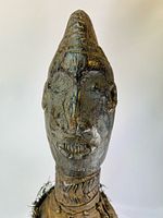 Close-up of head showing facial carving and patina