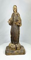 Front view of full santo statue showing pose, pedestal, paint remnants and cracks