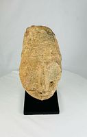 Front view of terracotta head fragment on metal stand