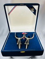 Pair of engraved nickel silver spurs in blue velvet case, lid open
