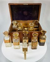 open mahogany box showing interior compartments and bottles arranged in front