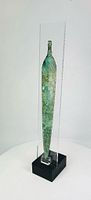 Front view of entire dagger blade in acrylic case on black base