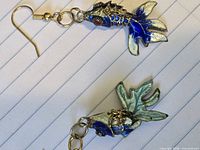 Full view of both articulated fish earrings showing color and hooks