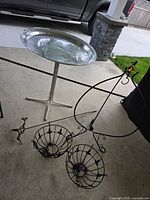 Group shot of birdbath, wrought iron stand, two wire baskets, hummingbird and frog stakes