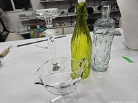 Group view: crystal candlestick, green bottle, embossed clear bottle, clear gravy boat