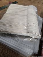 Bundle of wooden spoons atop stack of clear bags