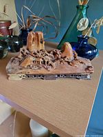 Full view of variegated soapstone mountain landscape carving on shelf