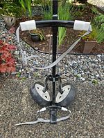 Front view of folded cart showing wheels, straps, and handle