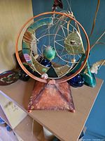 Front view showing circular frame, stained glass pieces, and pyramid base