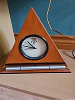Front view of triangular wood alarm clock
