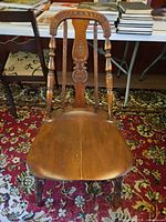 Front view of brown solid wood dining chair on rug