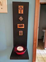 Full view of wall sconce mounted on wall with tealight holder in place