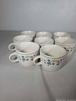 Group view of all eight matching stoneware mugs