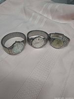 Group shot of three stainless steel wristwatches showing dial colours and band styles