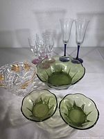 Group view of crystal bowl, three green bowls, two blue-stem flutes, five clear cordial glasses