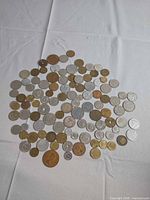 Wide view of entire spread of assorted coins on white fabric