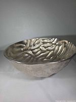 Angled side view of silver textured metal bowl
