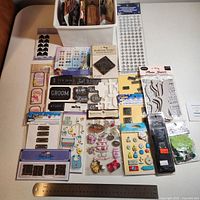 Overview of all alcohol inks and sticker packs on table with ruler for scale