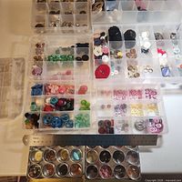 Overview of multiple containers filled with assorted buttons