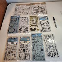 Overview of all ten sealed clear stamp packages laid out on table