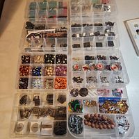 Overview of eight plastic organizers filled with assorted embellishments