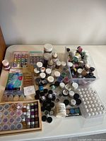 Entire lot overview on tabletop, showing jars, trays, adhesives, ink pads