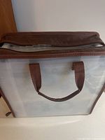 Portable clear file tote with brown trim and handles