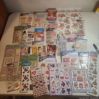 Overall lot view showing all sticker packs spread on table