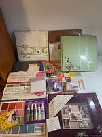 Overview showing handmade paper pad, green album, adhesives, gem box, cardstock packs
