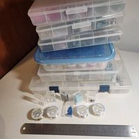 Stacked clear compartment cases, bead jars, findings