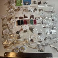 Wide view showing numerous bags of beads, findings, two wire spools and ruler for scale