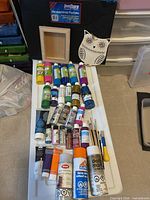 Full lot view showing paints, brushes, spray cans, portfolio, wood items