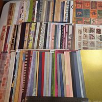 Wide view showing multiple rows of assorted 12"x12" scrapbooking papers with differing designs and colours