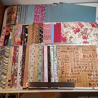 Full spread of stacked patterned 12x12 scrapbooking papers with ruler for scale
