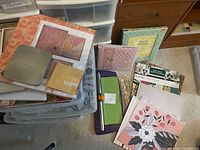 Overall view of scrapbooking supplies including plastic cases, albums, Fiskars trimmer and papers